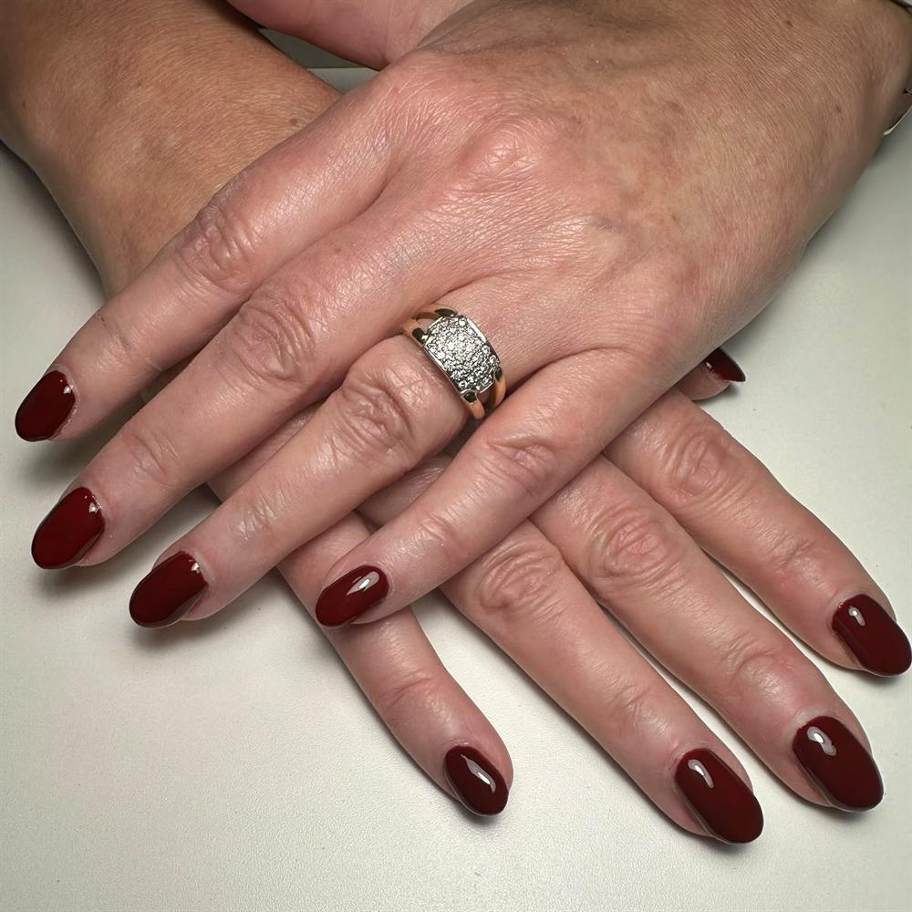 Gellak op natuurlijke nagels in een diepe bordeauxrode kleur