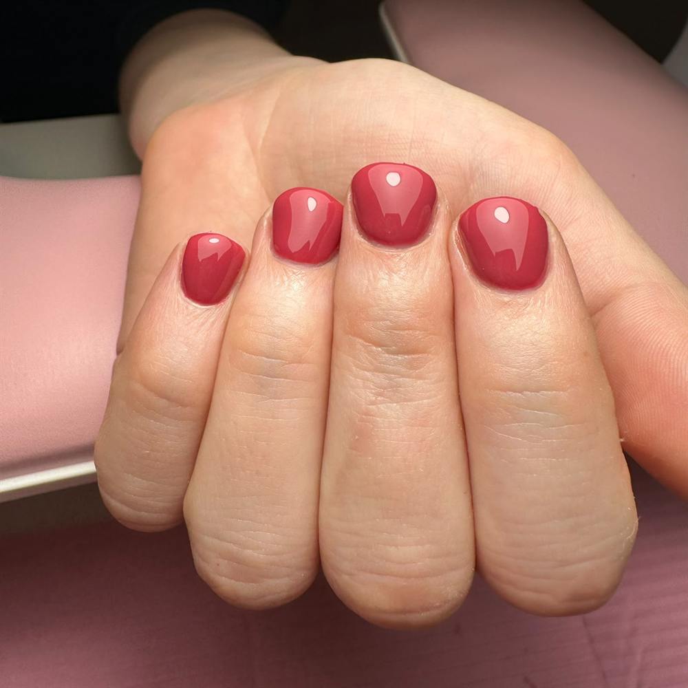 Korte nagels in een frambooskleurige gellak